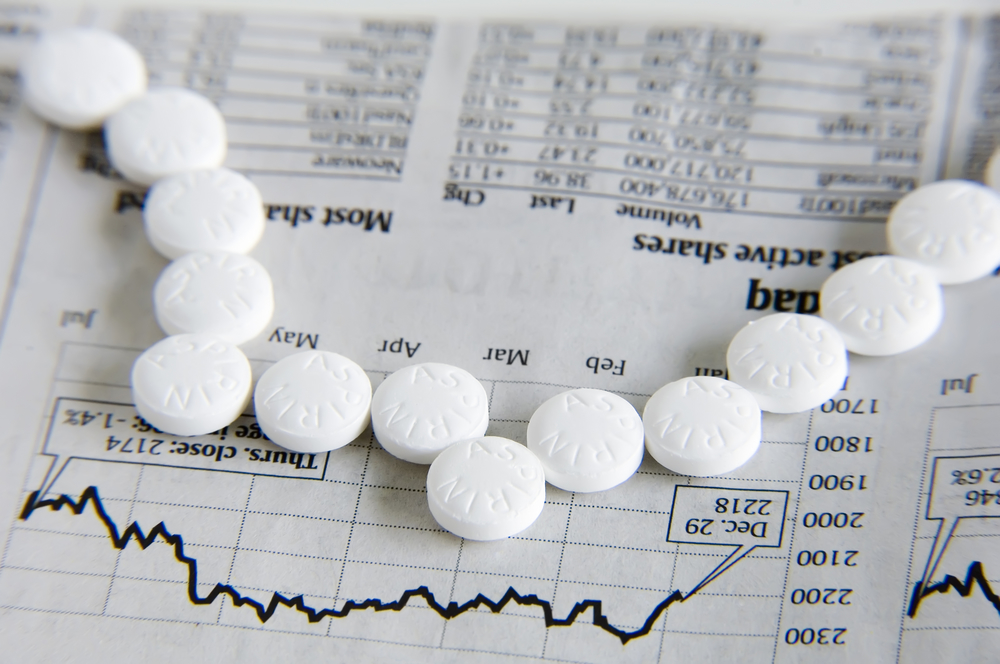 Row of aspirin peaked like daily graph of stock market